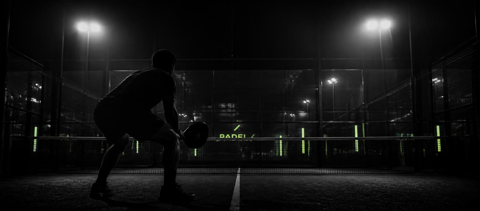 Padel players on a floodlit court